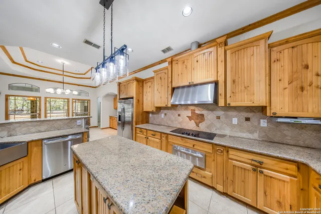 a kitchen with stainless steel appliances granite countertop a sink stove and cabinets