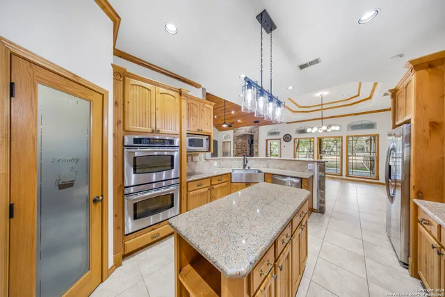 a kitchen with stainless steel appliances granite countertop a refrigerator a oven and a sink