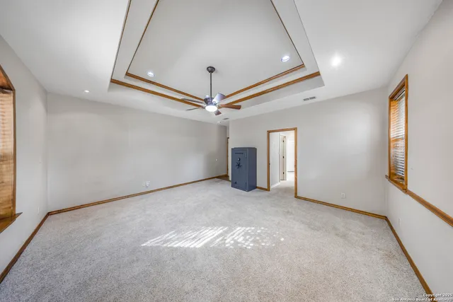 en empty room with windows and ceiling fan