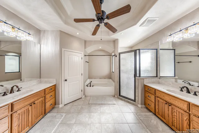 a spacious bathroom with a double vanity sink a mirror and a bathtub