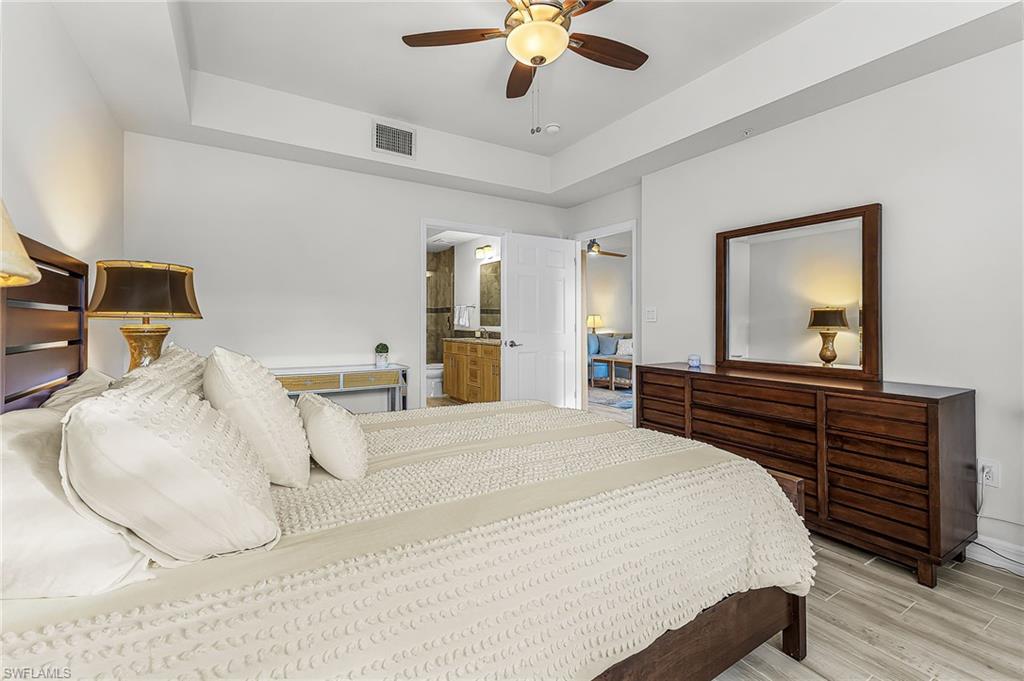 401 Bayfront Place, Unit 3405 Naples, FL 34102 - Photo 18 of 31 a bedroom with a large bed and a chandelier