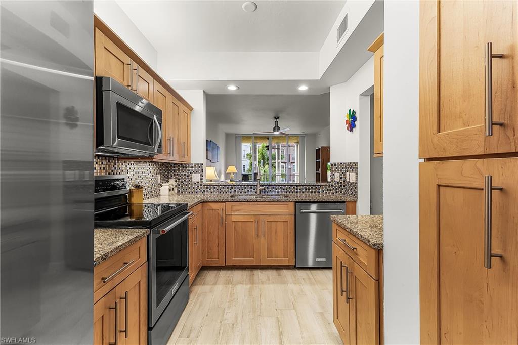 401 Bayfront Place, Unit 3405 Naples, FL 34102 - Photo 8 of 31 a kitchen with stainless steel appliances granite countertop a refrigerator a stove top oven a sink and dishwasher