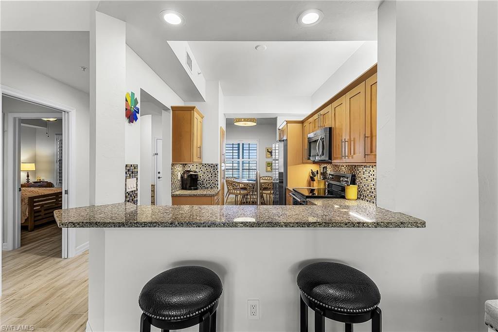 401 Bayfront Place, Unit 3405 Naples, FL 34102 - Photo 9 of 31 a bathroom with a granite countertop sink a toilet and mirror