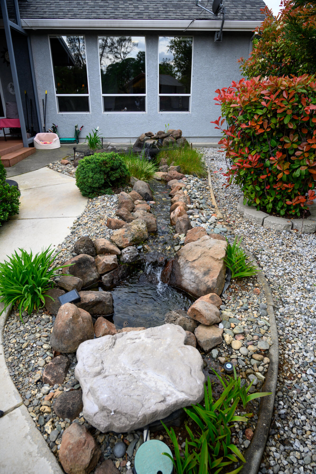 2071 Hope Lane Redding, CA 96003 - Photo 11 of 45 a front view of a house with a yard and a garden