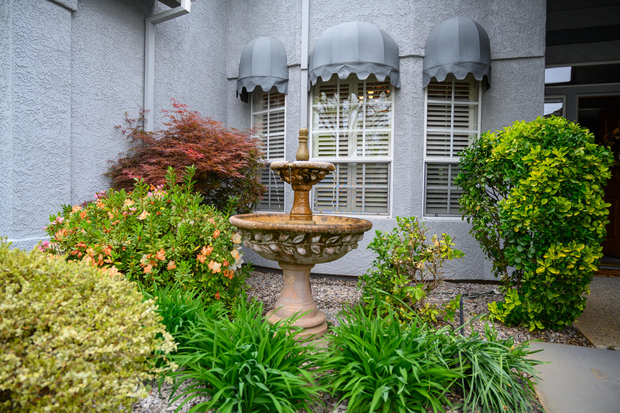 2071 Hope Lane Redding, CA 96003 - Photo 4 of 45 a view of a house with large windows and flower plants