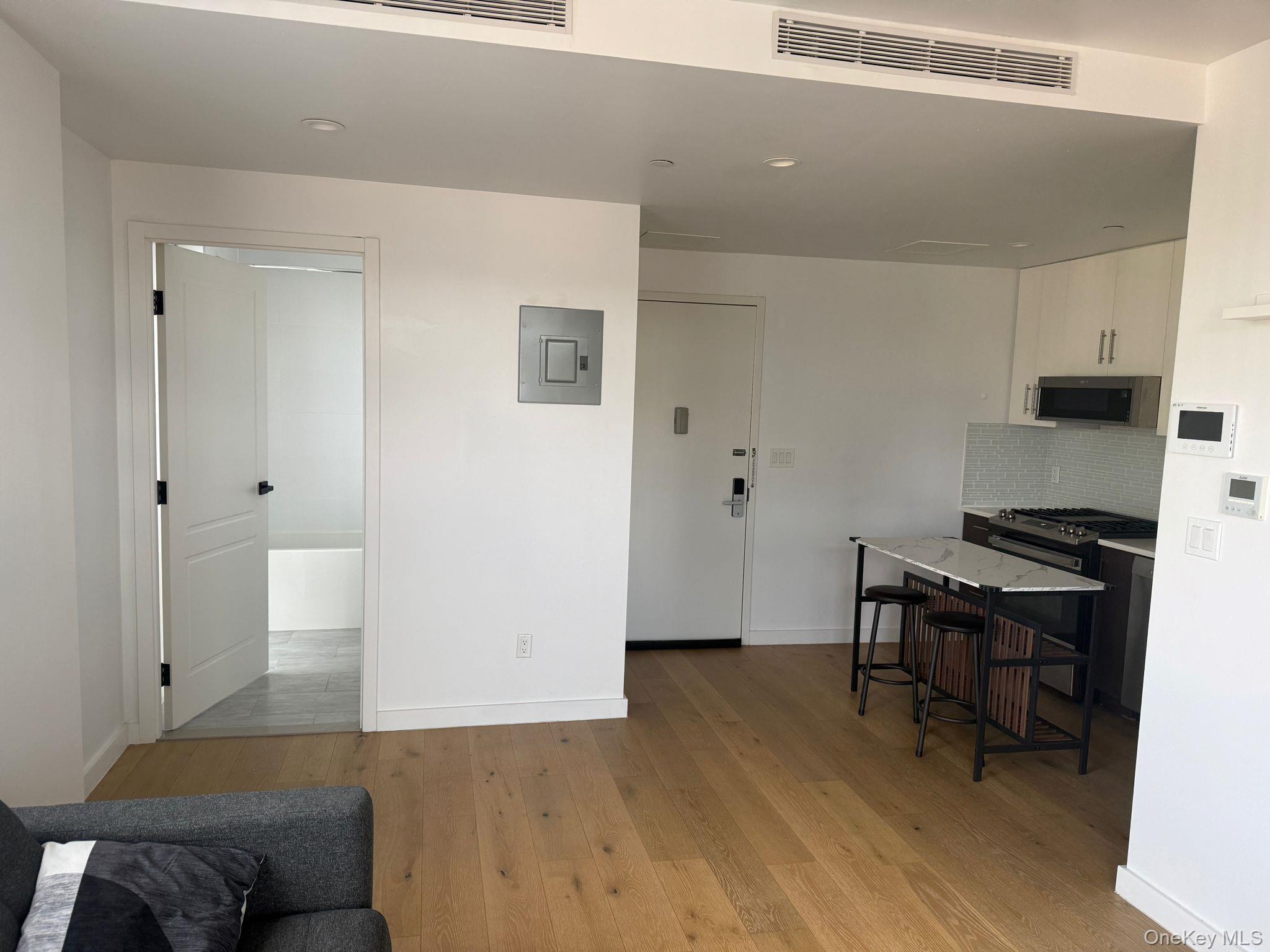 97-29 64th Road Queens, NY 11374 - Photo 3 of 12 a workspace with furniture and wooden floor