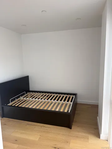 a bedroom with a bed and a lamp on the dresser