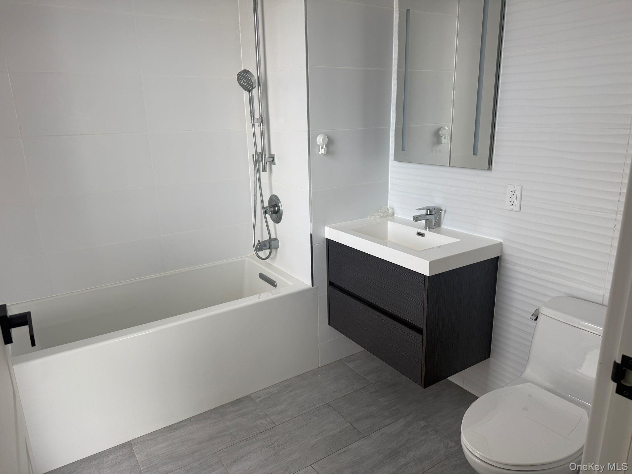 97-29 64th Road Queens, NY 11374 - Photo 8 of 12 a bathroom with a sink a toilet and bathtub