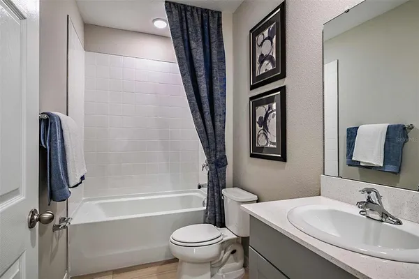 a bathroom with a granite countertop toilet a sink and a mirror