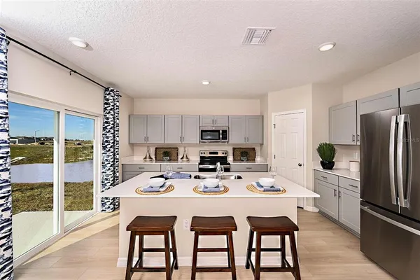 a kitchen with stainless steel appliances kitchen island granite countertop a dining table and chairs