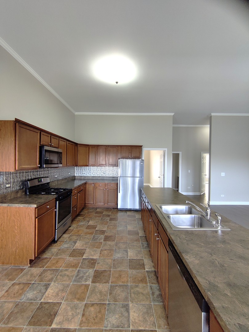 2026 North 3372nd Road, Unit 503 Ottawa, IL 61350 - Photo 16 of 49 a large kitchen with granite countertop a sink and cabinets