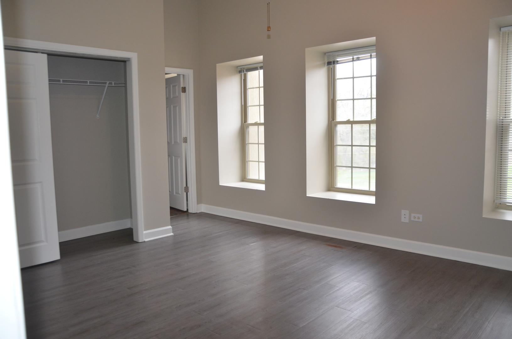 2026 North 3372nd Road, Unit 503 Ottawa, IL 61350 - Photo 45 of 49 an empty room with wooden floor and windows with curtains