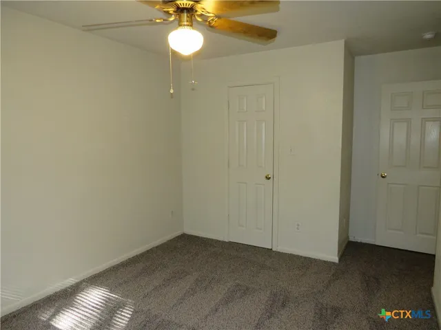 a view of a room with a hanging light and kitchen