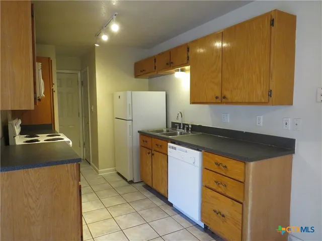 a kitchen with granite countertop a refrigerator and a stove