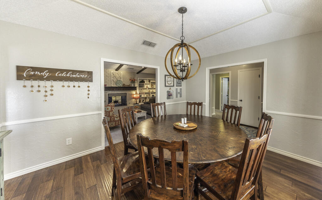 3620 93rd Street Lubbock, TX 79423 - Photo 9 of 33 a view of a dining room with furniture wooden floor and chandelier