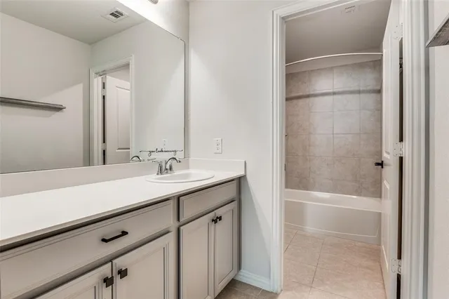 an empty room with a chandelier fan and windows