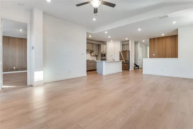 a view of kitchen with refrigerator stove and wooden floor