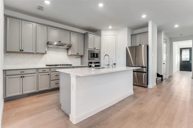 a kitchen with stainless steel appliances a sink stove and refrigerator