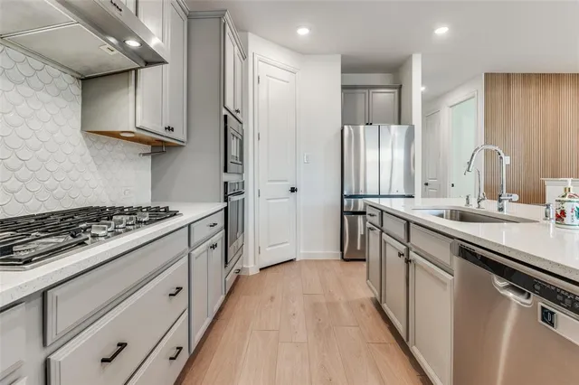 a kitchen with stainless steel appliances a stove a refrigerator and a cabinets
