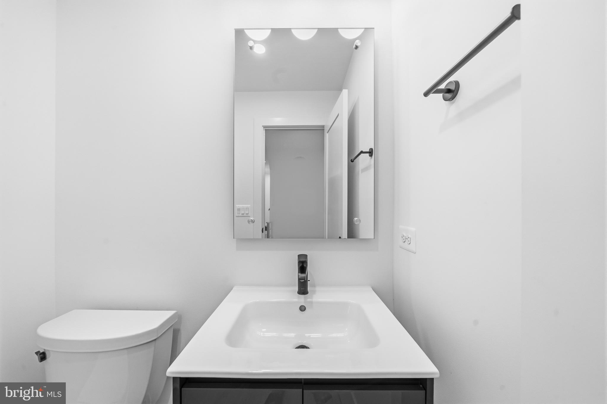 2040 Tysons Ridgeline Road Falls Church, VA 22043 - Photo 21 of 56 a bathroom with a sink a toilet and mirror