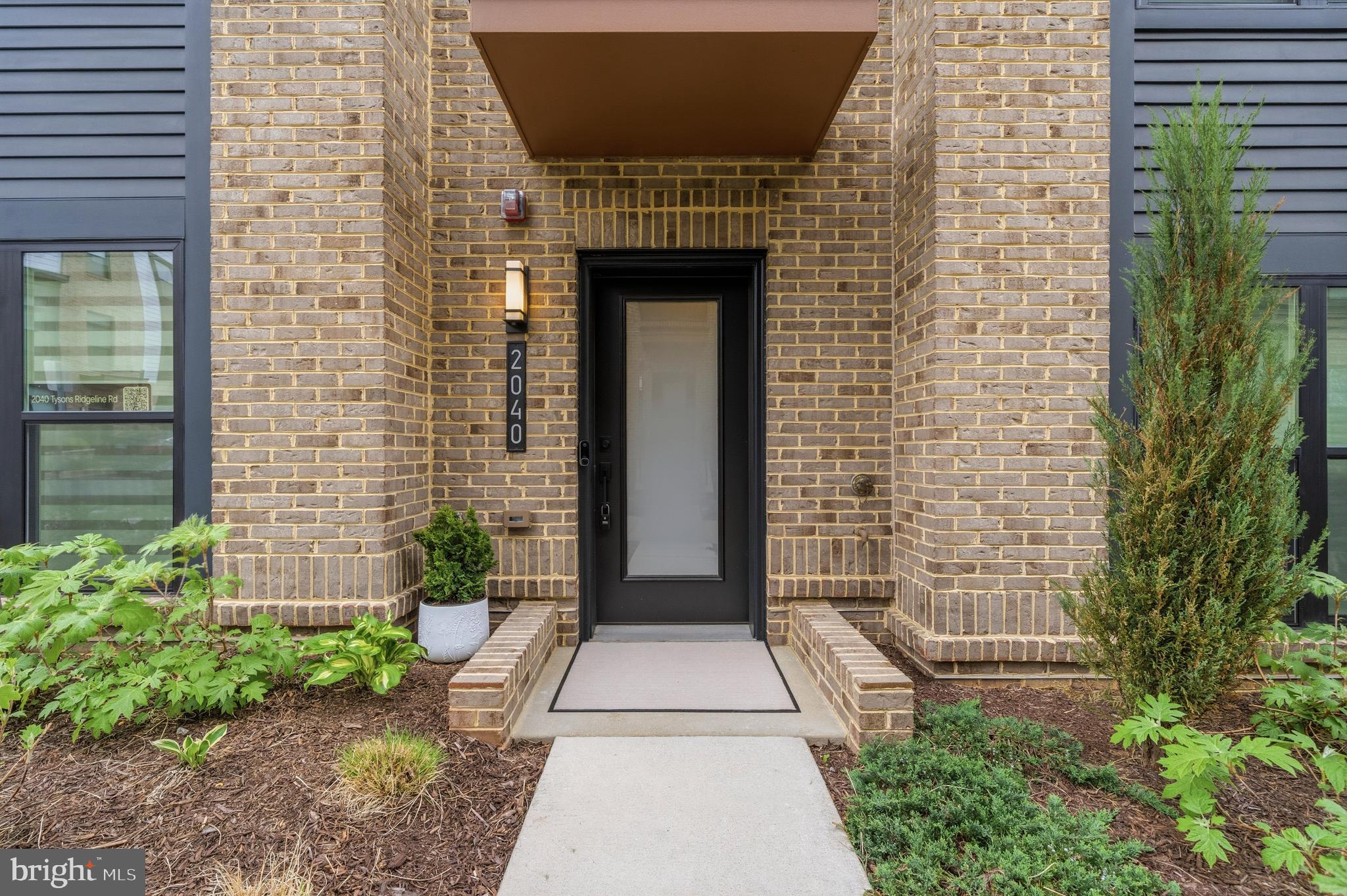 2040 Tysons Ridgeline Road Falls Church, VA 22043 - Photo 4 of 56 a front view of a house with a garden