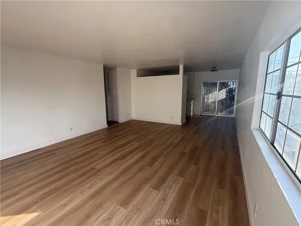 a view of a big room with wooden floor and stairs