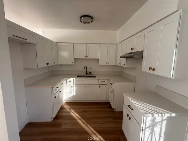 a kitchen with granite countertop white cabinets and white appliances