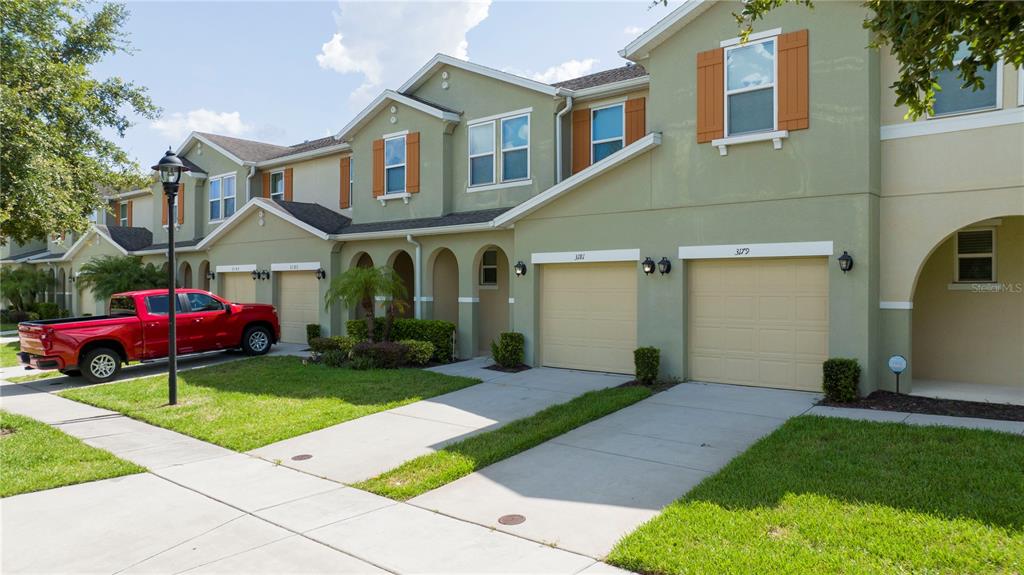 a front view of a house with a yard and potted plants
