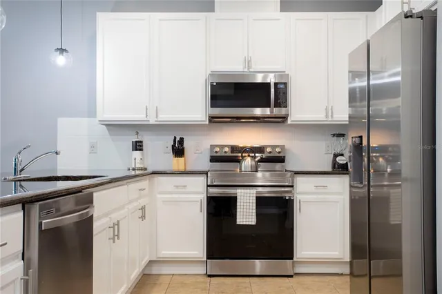 a living room with furniture kitchen view and a chandelier