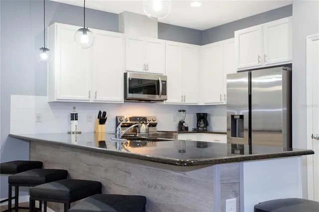 a living room kitchen with stainless steel appliances kitchen island granite countertop furniture and a view of kitchen