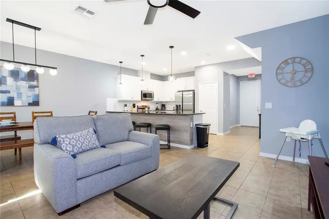 a living room with furniture a ceiling fan and a window