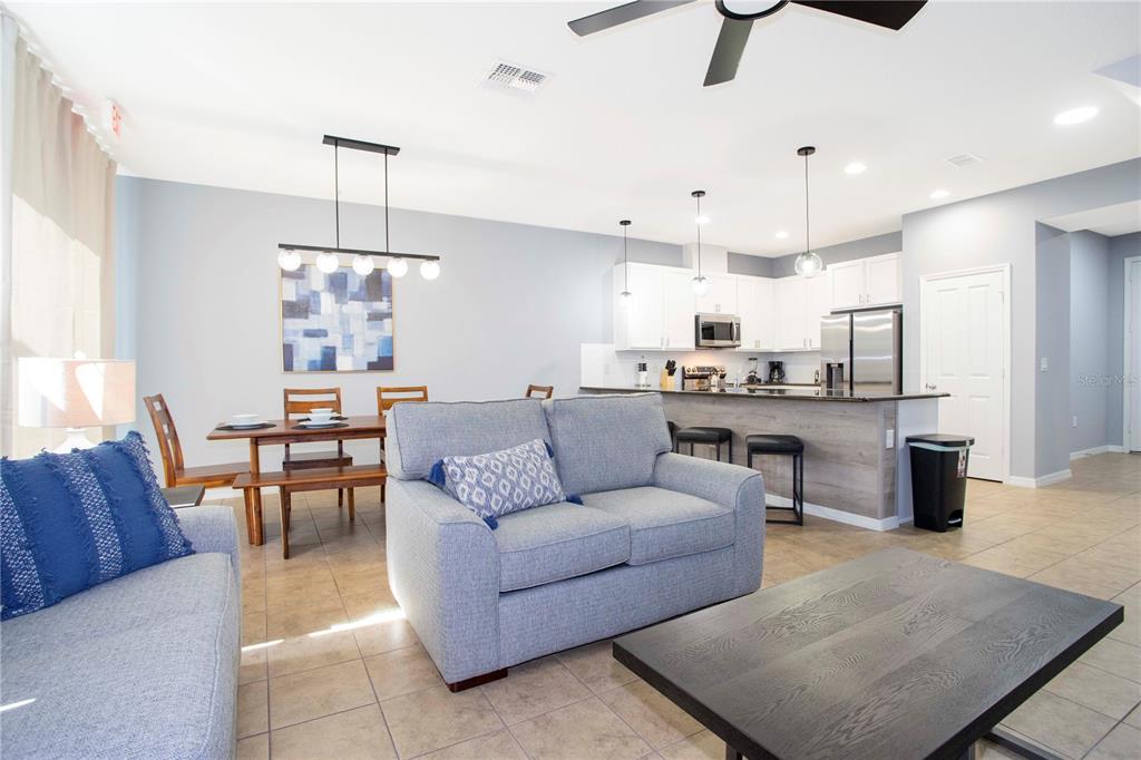 3181 Tocoa Circle Kissimmee, FL 34746 - Photo 27 of 87 a living room kitchen with stainless steel appliances kitchen island granite countertop furniture and a view of kitchen