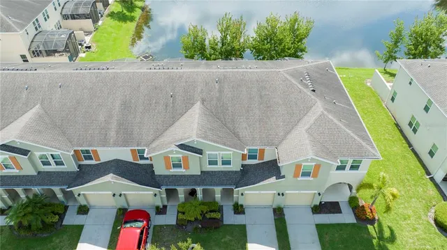 an aerial view of a house with a garden and lake view