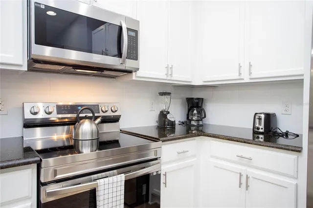 a bedroom with a bed a flat screen tv and a chandelier