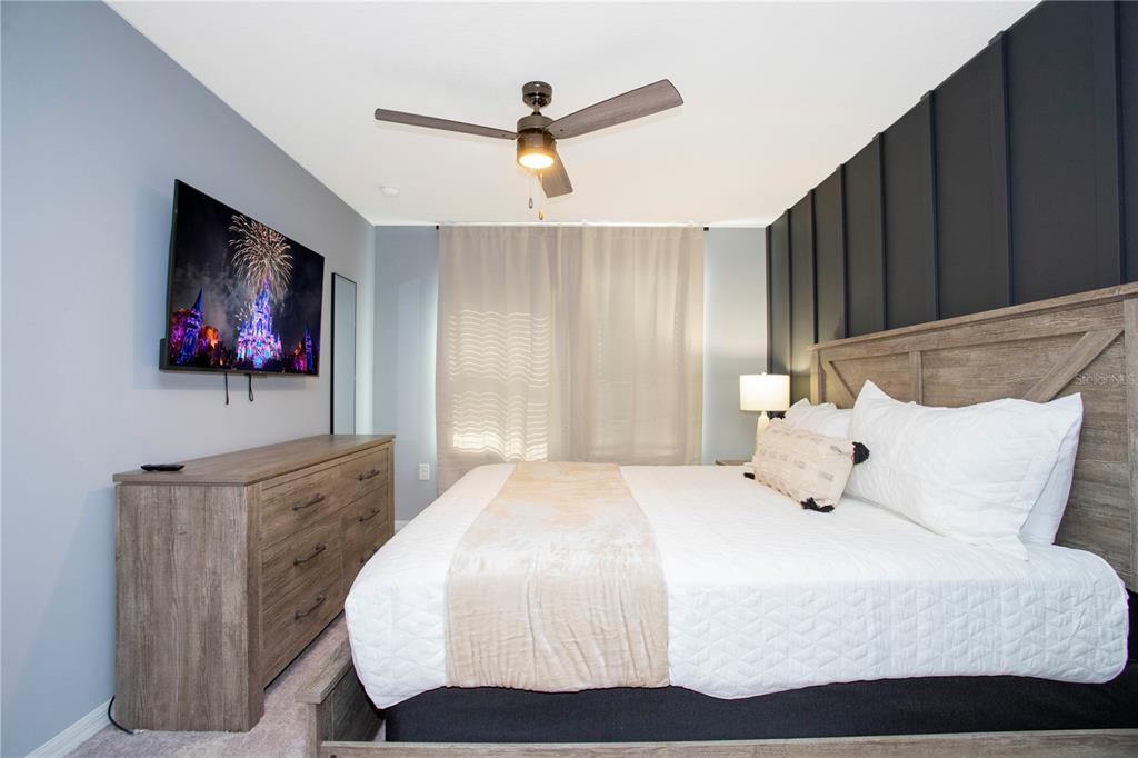 3181 Tocoa Circle Kissimmee, FL 34746 - Photo 84 of 87 a bedroom with a bed a flat screen tv and a couch