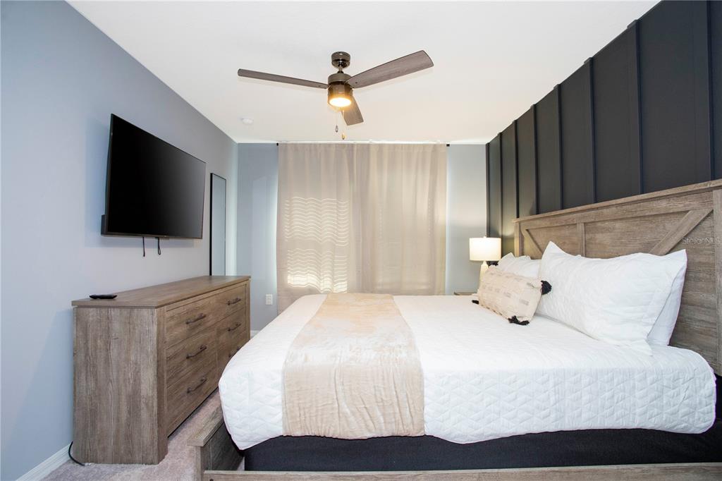 3181 Tocoa Circle Kissimmee, FL 34746 - Photo 85 of 87 a bedroom with a bed a flat screen tv and a chandelier