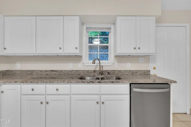 a kitchen with a sink cabinets and a window