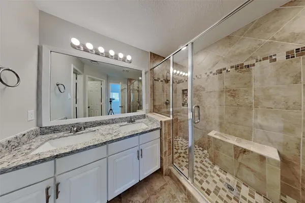 a bathroom with a double vanity sink and a mirror
