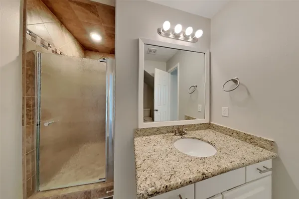 a bathroom with a granite countertop sink and a mirror