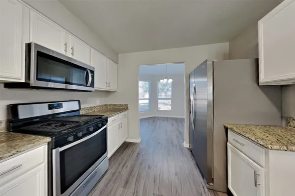 a kitchen with stainless steel appliances kitchen island granite countertop a stove a sink and a microwave