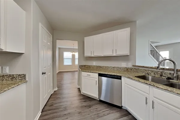 a kitchen with granite countertop a sink and cabinets
