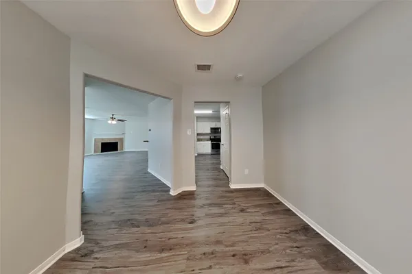 a view of empty room with wooden floor and window