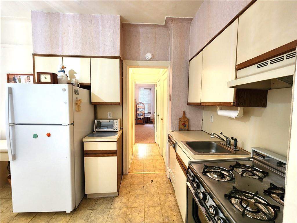 8735 Bay Parkway, Unit A57 Brooklyn, NY 11214 - Photo 11 of 13 a kitchen with a stove a refrigerator and a sink