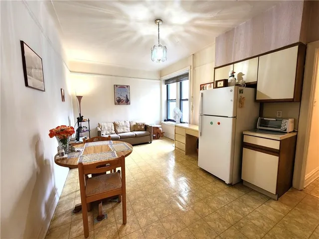 a living room with furniture a refrigerator and a fireplace