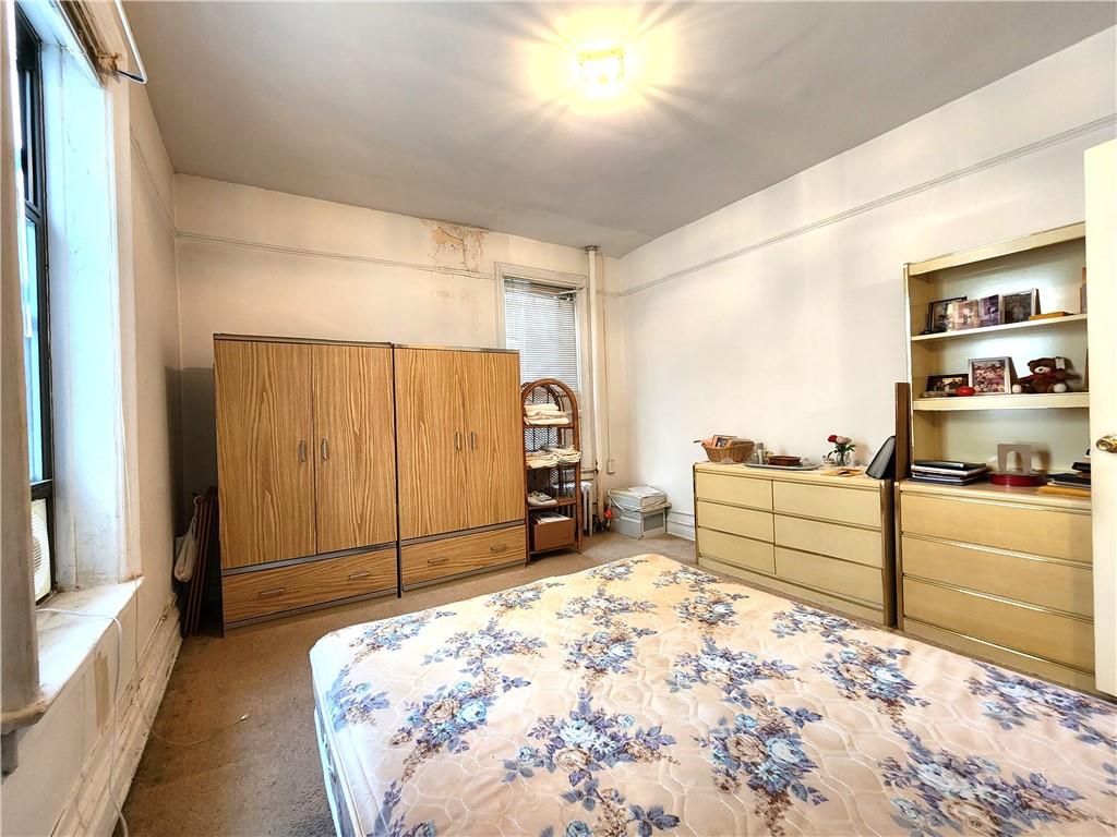 8735 Bay Parkway, Unit A57 Brooklyn, NY 11214 - Photo 7 of 13 a bedroom with a bed and a dresser