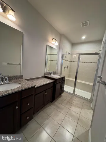 a bathroom with a granite countertop sink a mirror and a bathtub