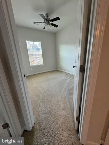 an empty room with a ceiling fan and window