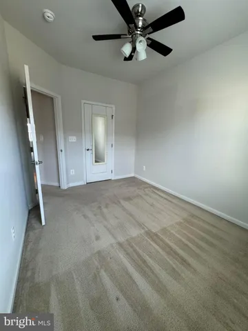 a view of an empty room with a chandelier fan