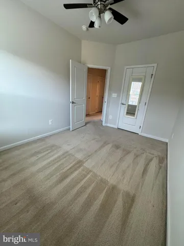 an empty room with fan and windows