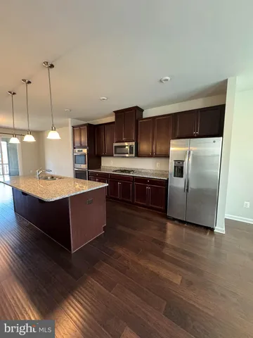 a large kitchen with wooden floors and stainless steel appliances